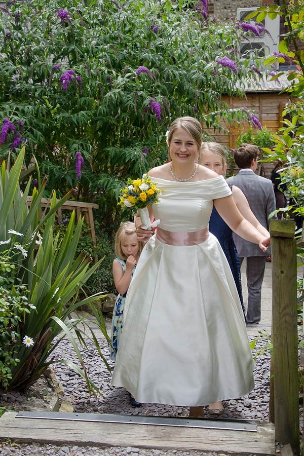 Bride in the pub garden with bouquet