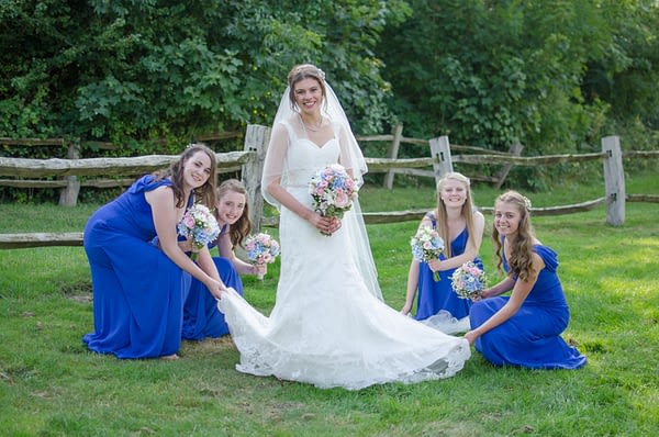 Bride with bridesmaids spreading her dress