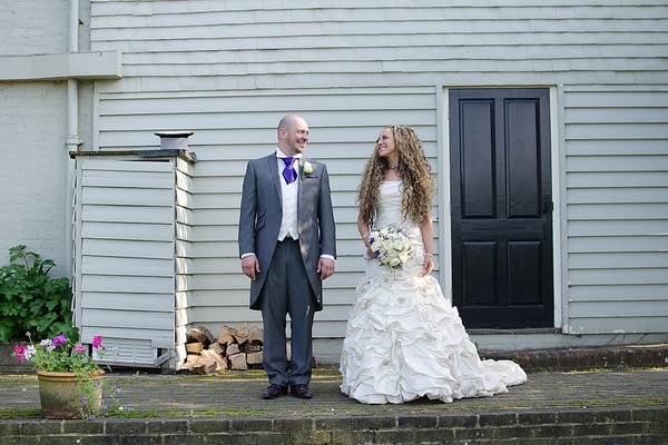 Quirky wedding photography with bride and groom looking at ecah other with top hat and other features